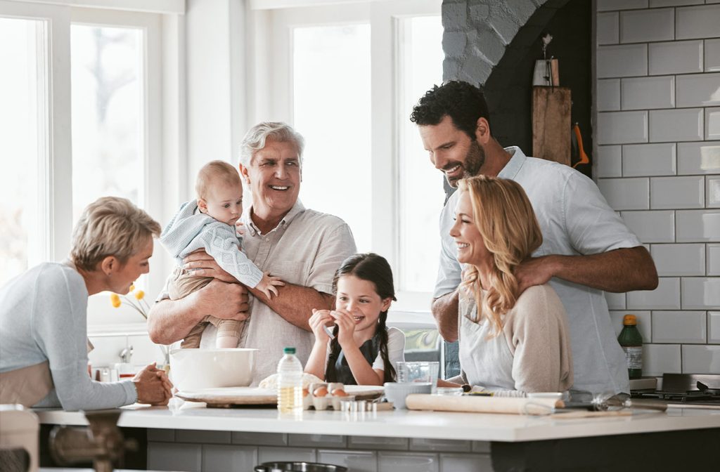 Smiling Grandparents and happy young family in the kitchen